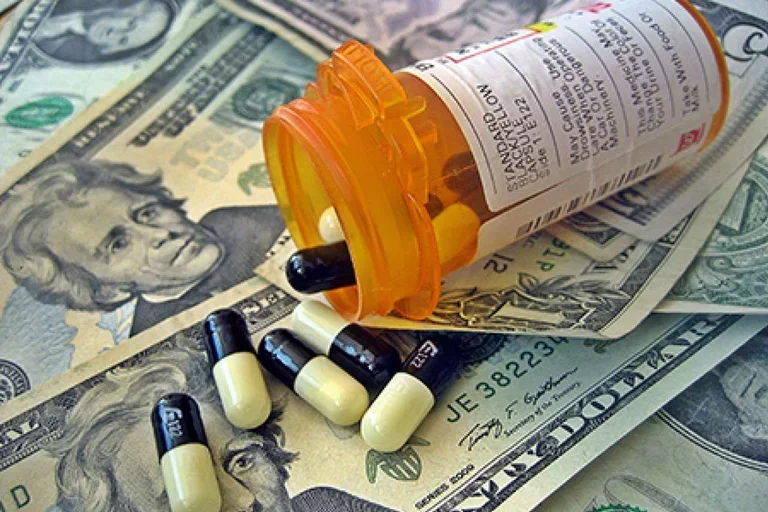 Open bottle of medication pills on top of dollar bills