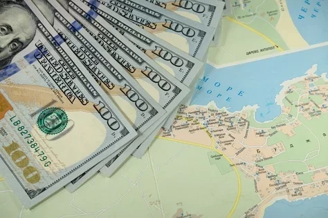 Paper money is spread out on top of a map.